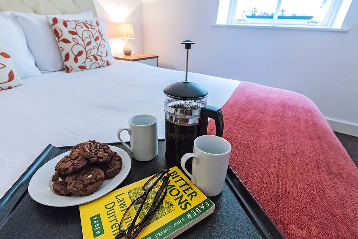 Plymouth Serviced Apartments - comfy apartment with coffee and cookies on bed