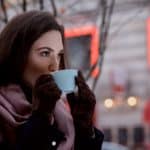 lady in the cold outside drinking coffee