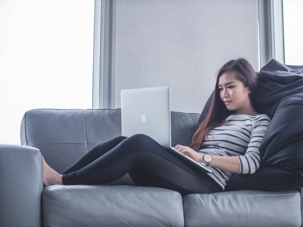 lady on a sofa doing work on laptop