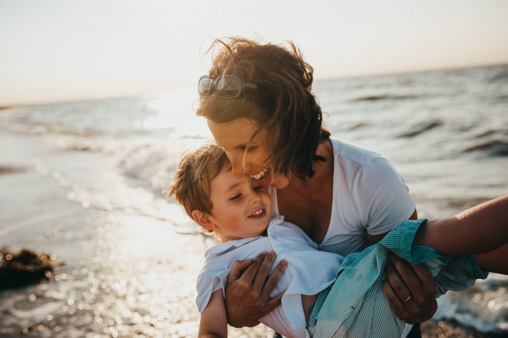 Mum and son by the sea laughing